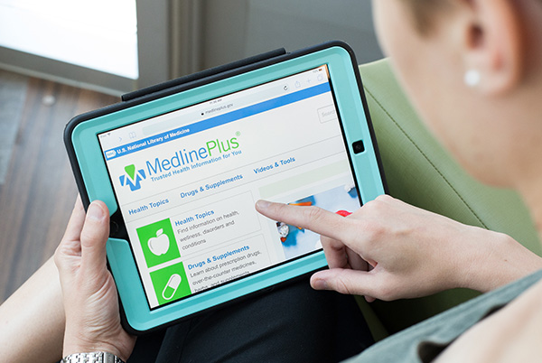 Man holds a tablet and looks at health information.