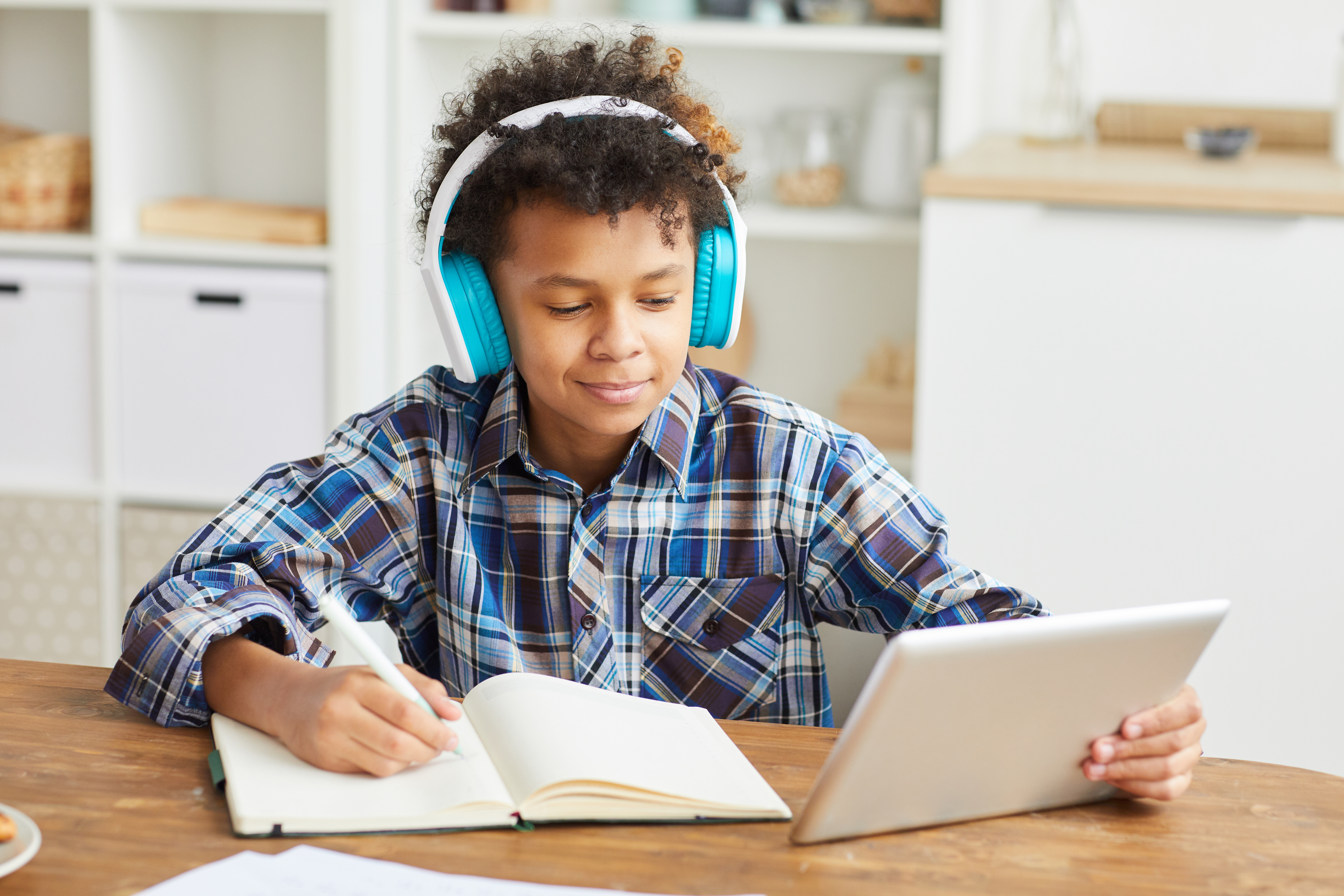 Boy reading with headphones and tablet