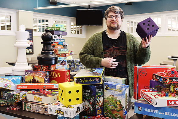 Chase Caudill posing with items from Board Games collection
