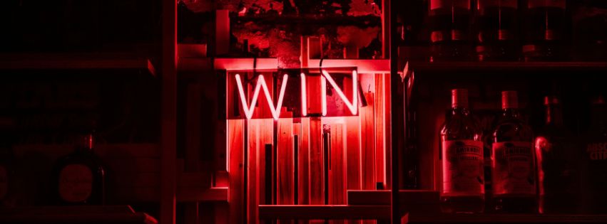 the word "win" in a neon light display in a dark room