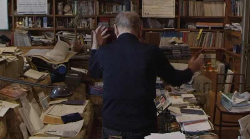 A cluttered room with Ennio at the center
