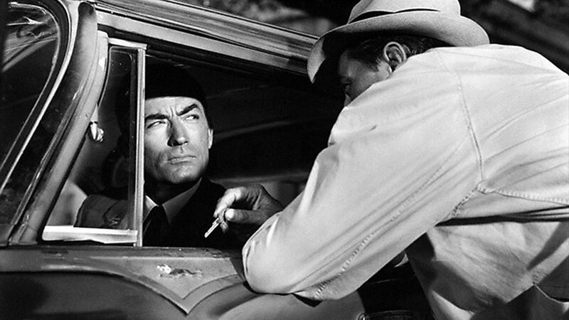 Robert Mitchum leans on Gregory Peck's car