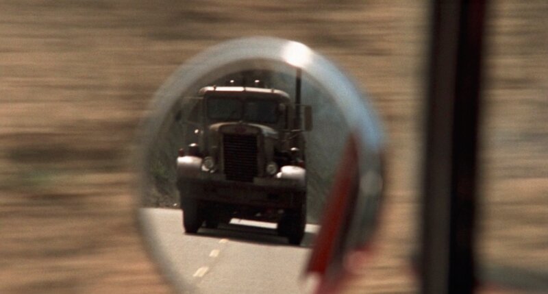 the truck appears in the rearview mirror