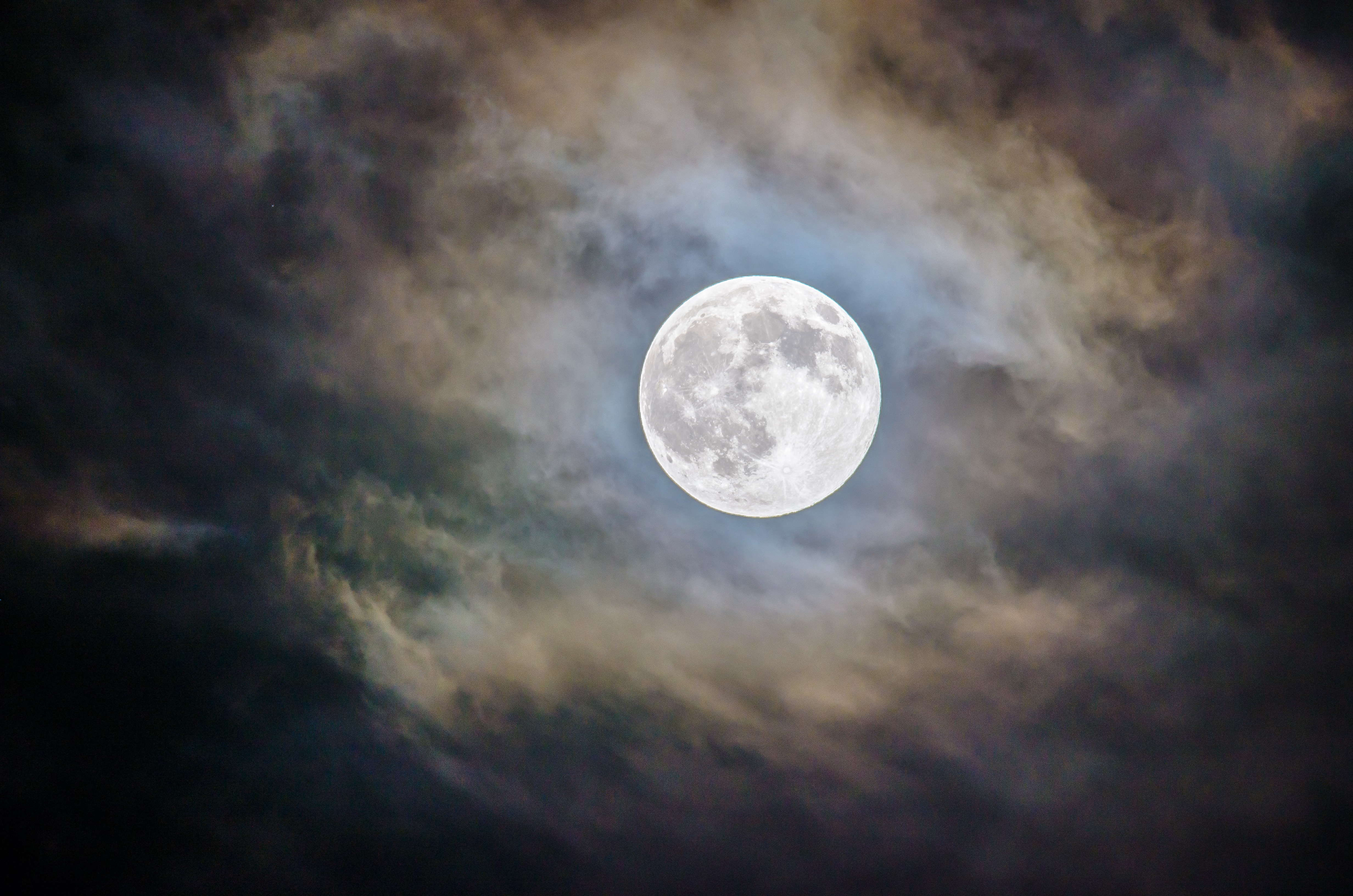 Full moon in a cloudy night sky.