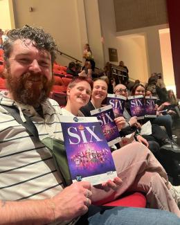 Joseph (far left) and young people from Just Us attend a performance of "Six: the Musical." (Image courtesy of Joseph Clark/Oasis Center.)