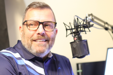 NPL volunteer David sits next to a microphone.