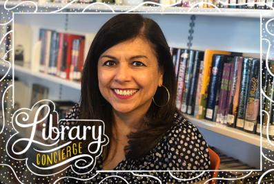 Woman with dark hair stands in a library.